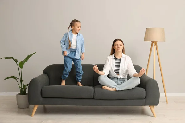 Mãe Meditando Enquanto Filha Distraindo Casa — Fotografia de Stock