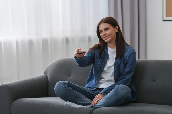 Glückliche Frau Wechselt Fernsehkanäle Mit Fernbedienung Auf Dem Heimischen Sofa — Stockfoto