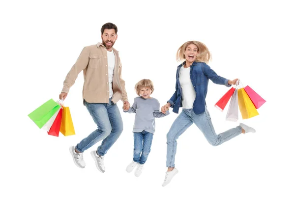 ファミリーショッピング 幸せな両親と息子は白い背景に多くのカラフルなバッグでジャンプ — ストック写真