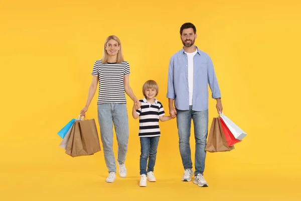 Shopping Famiglia Felice Genitori Figlio Con Sacchetti Carta Sfondo Arancione — Foto Stock