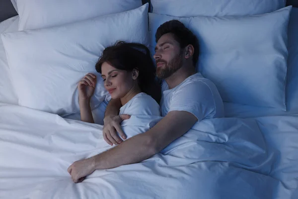 Lovely couple sleeping together in bed at night