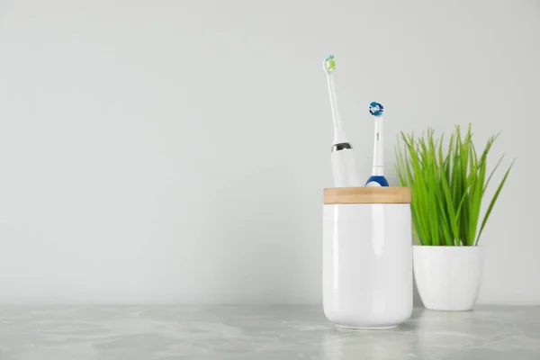 Electric Toothbrushes Holder Green Houseplant Light Grey Marble Table White — Stock Photo, Image