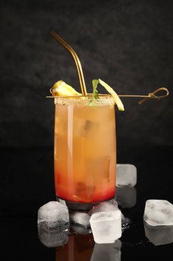 Siyah ayna yüzeyinde buz küpleri olan lezzetli ananas kokteyli.