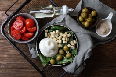 Zeytin, kızarmış ekmek, fesleğen ve domatesle servis edilen nefis burrata peyniri.