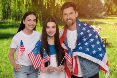 4 Temmuz - Amerika 'nın Bağımsızlık Günü. Ulusal bayraklı mutlu aile parkta piknik yapıyor.