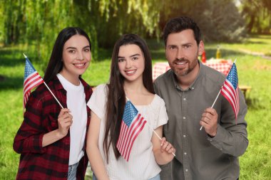 4 Temmuz - Amerika 'nın Bağımsızlık Günü. Ulusal bayraklı mutlu aile parkta piknik yapıyor.