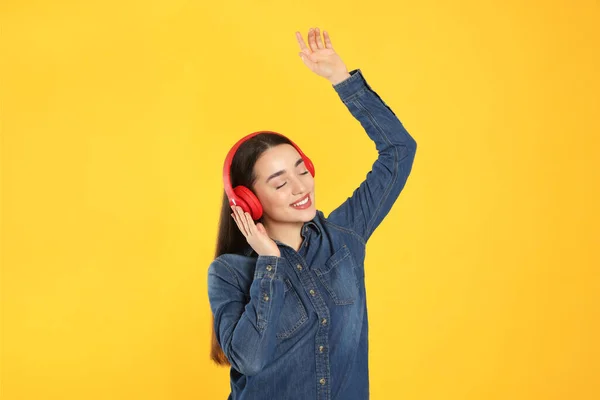 Щаслива Жінка Навушниках Слухає Музику Танцює Помаранчевому Фоні — стокове фото