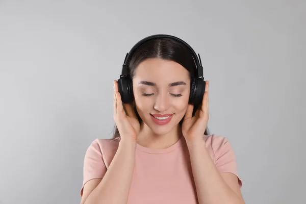 Ευτυχισμένη Γυναίκα Ακουστικά Απολαμβάνοντας Μουσική Γκρι Φόντο — Φωτογραφία Αρχείου