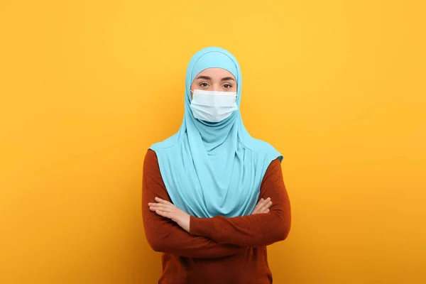 带头巾的穆斯林妇女画像和橙色背景的医疗面具 — 图库照片