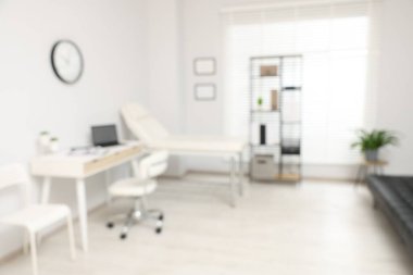 Doktorun çalışma alanı ve klinikteki muayene masası ile modern tıp bürosunun bulanık görünümü
