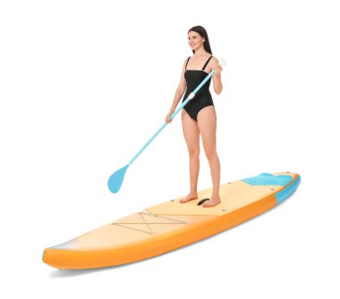 Beyaz arka planda turuncu SUP tahtasıyla kürek çeken mutlu bir kadın.