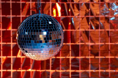 Renkli ışıklar altında folyo parti perdesine karşı parlak disko topu, metin için boşluk