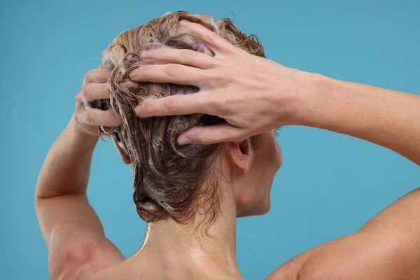 浅蓝色背景的妇女洗头 — 图库照片