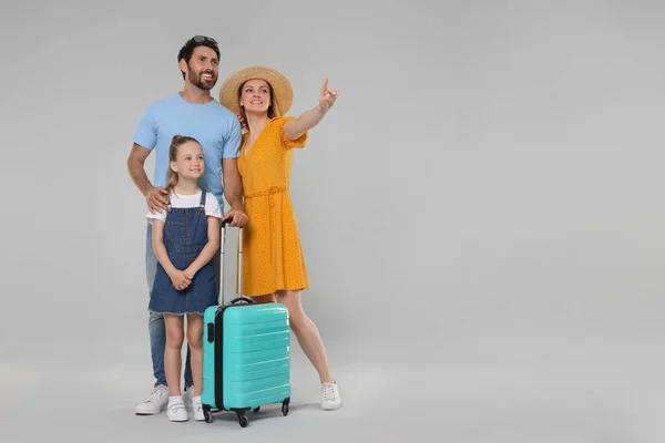 Família Feliz Com Mala Turquesa Sobre Fundo Cinza Claro Espaço — Fotografia de Stock