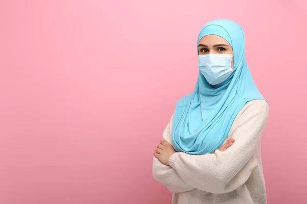 带头巾的穆斯林妇女画像和粉色背景的医疗面具 文字空间 — 图库照片