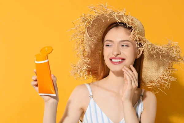 Όμορφη Νεαρή Γυναίκα Ψάθινο Καπέλο Κρατώντας Αντηλιακή Κρέμα Προστασίας Πορτοκαλί — Φωτογραφία Αρχείου