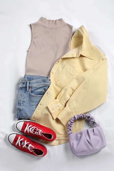 Ζεύγος Από Stylish Κόκκινα Sneakers Ρούχα Και Τσάντα Λευκό Ύφασμα — Φωτογραφία Αρχείου