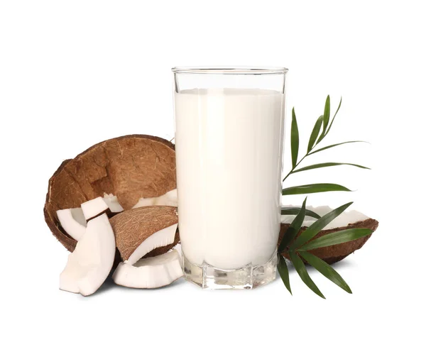 おいしいビーガンミルク ココナッツ片と白い背景に緑の葉のガラス — ストック写真