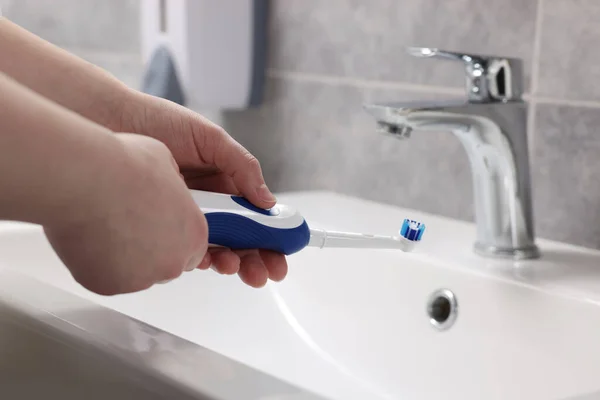 Mulher Segurando Escova Dentes Elétrica Acima Pia Banheiro Close — Fotografia de Stock