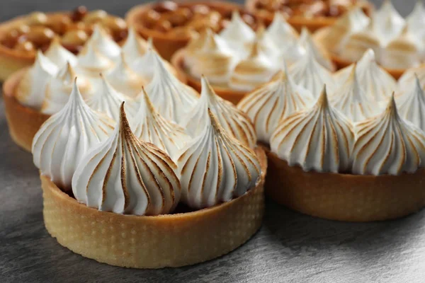 stock image Many different tartlets on dark grey table, closeup. Tasty dessert