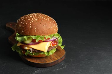 Köfteli leziz burger ve lahanalı siyah masa, mesaj için yer var.