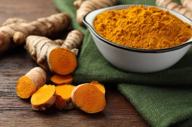 Aromatik zerdeçal tozu ve ahşap masaya kök salmış, yakın plan.
