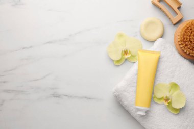 Beyaz mermer masa üzerinde spa ürünleri ve güzel çiçeklerle bembeyaz bir kompozisyon sergiliyordu. Metin için boşluk