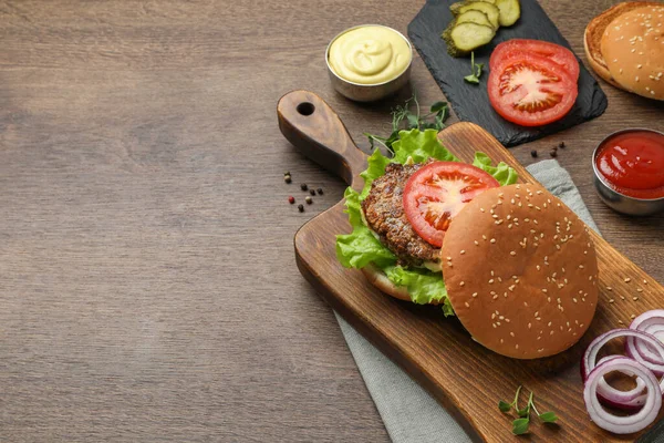 테이블에 쇠고기 패티와 재료와 맛있는 햄버거 텍스트 — 스톡 사진