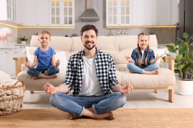 Çocuklu baba evde meditasyon yapıyor. Ahenk ve zen