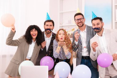 İş arkadaşları ofis partisinde eğleniyor.