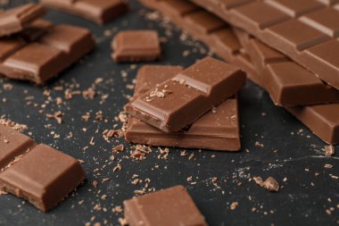 Lezzetli çikolata parçaları karanlık masada, yakın plan.