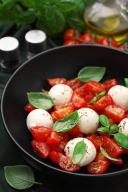 Domatesli Caprese salatası, mozzarella köftesi ve fesleğen, yakın plan.