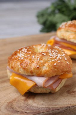 Ahşap masada jambon ve peynirli leziz simit, yakın plan.