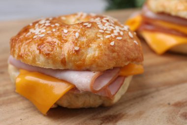 Ahşap masada jambon ve peynirli leziz simit, yakın plan.