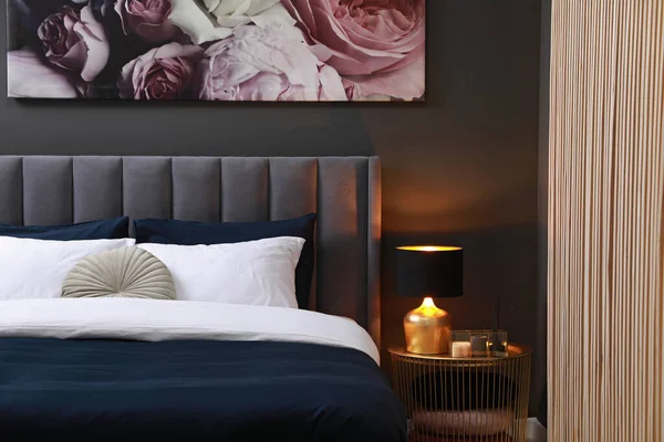 クッション ランプと部屋のベッドサイドテーブルの異なる装飾が施された快適なベッド スタイリッシュなインテリア — ストック写真