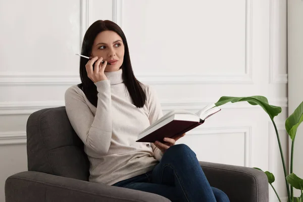 Evde Kitap Okurken Sigara Tutacağı Kullanan Bir Kadın — Stok fotoğraf