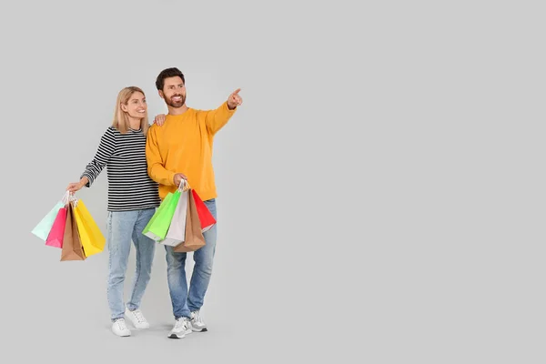 Familieneinkauf Glückliches Paar Mit Vielen Bunten Taschen Auf Hellgrauem Hintergrund — Stockfoto