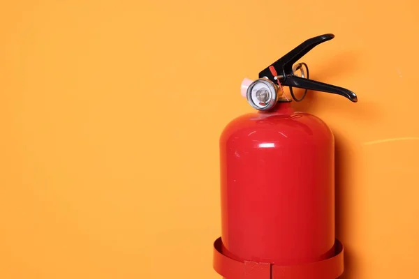 stock image Red fire extinguisher on orange background. Space for text