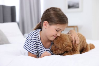 Evdeki yatakta küçük bir çocuk ve sevimli bir köpek yavrusu. Sevimli hayvan