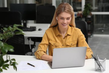 Ofisteki beyaz masada dizüstü bilgisayarda çalışan bir kadın. Metin için boşluk