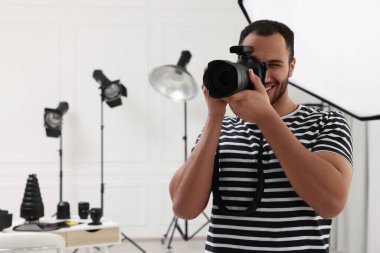 Modern fotoğraf stüdyosunda fotoğraf çeken genç profesyonel fotoğrafçı.