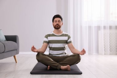 Adam evde meditasyon yapıyor. Ahenk ve zen