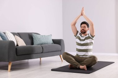 Man meditating at home, space for text clipart