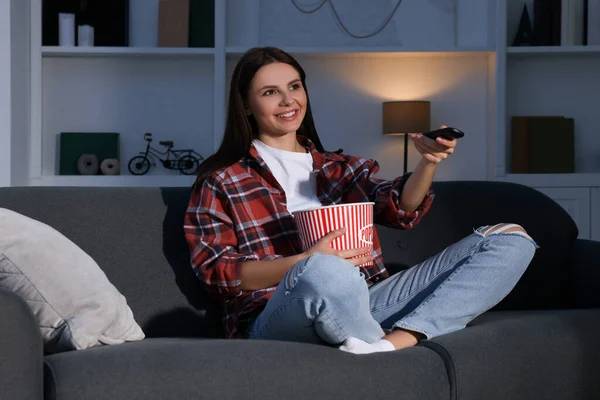 Šťastná Žena Drží Popcorn Vědro Přepínání Televizních Kanálů Dálkovým Ovládáním — Stock fotografie