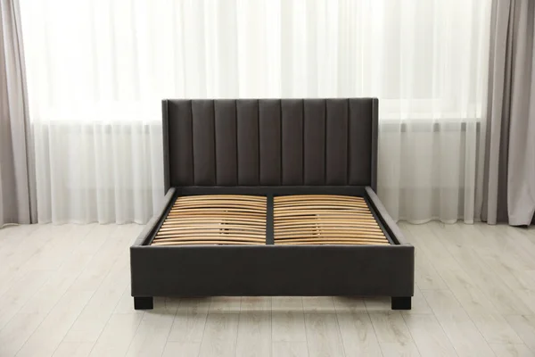 Modern bed with storage space for bedding under slatted base in room