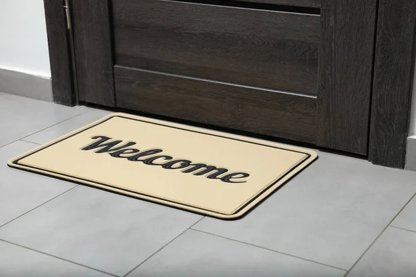 stock image Beautiful beige doormat with word Welcome on floor near entrance