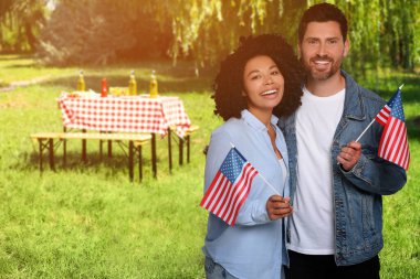 4 Temmuz - Amerika 'nın Bağımsızlık Günü. Ulusal bayraklı mutlu çift parkta piknik yapıyor.