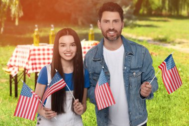 4 Temmuz - Amerika 'nın Bağımsızlık Günü. Amerika Birleşik Devletleri bayraklı mutlu baba ve kızı parkta piknik yapıyorlar.