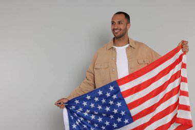 4 Temmuz - ABD 'nin Bağımsızlık Günü. Açık gri arka planda Amerikan bayrağı olan mutlu adam, metin için boşluk