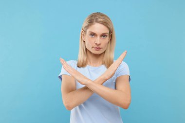 Kes jesti. Açık mavi arka planda çapraz elleri olan bir kadın.